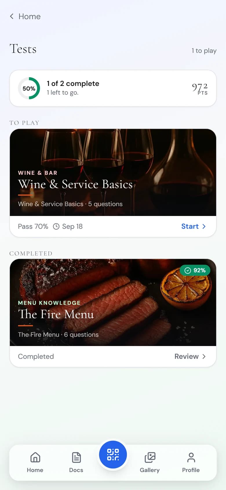 Priya’s Tests screen: The Fire Menu completed at 92%, Wine & Service Basics still to play.